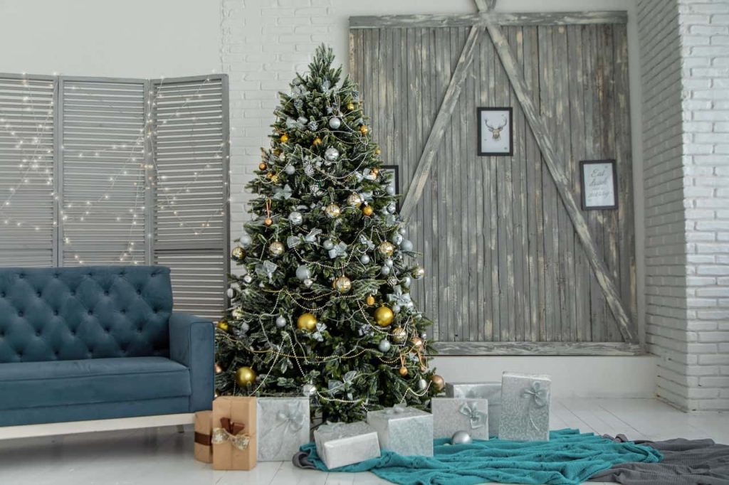 A green christmas tree with presents wrapped in grey wrapping paper underneath,