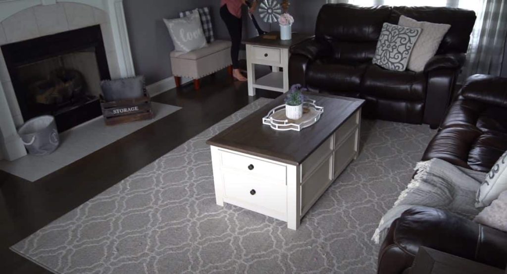 Cleaning lady wearing pink singlet vacuuming a living area