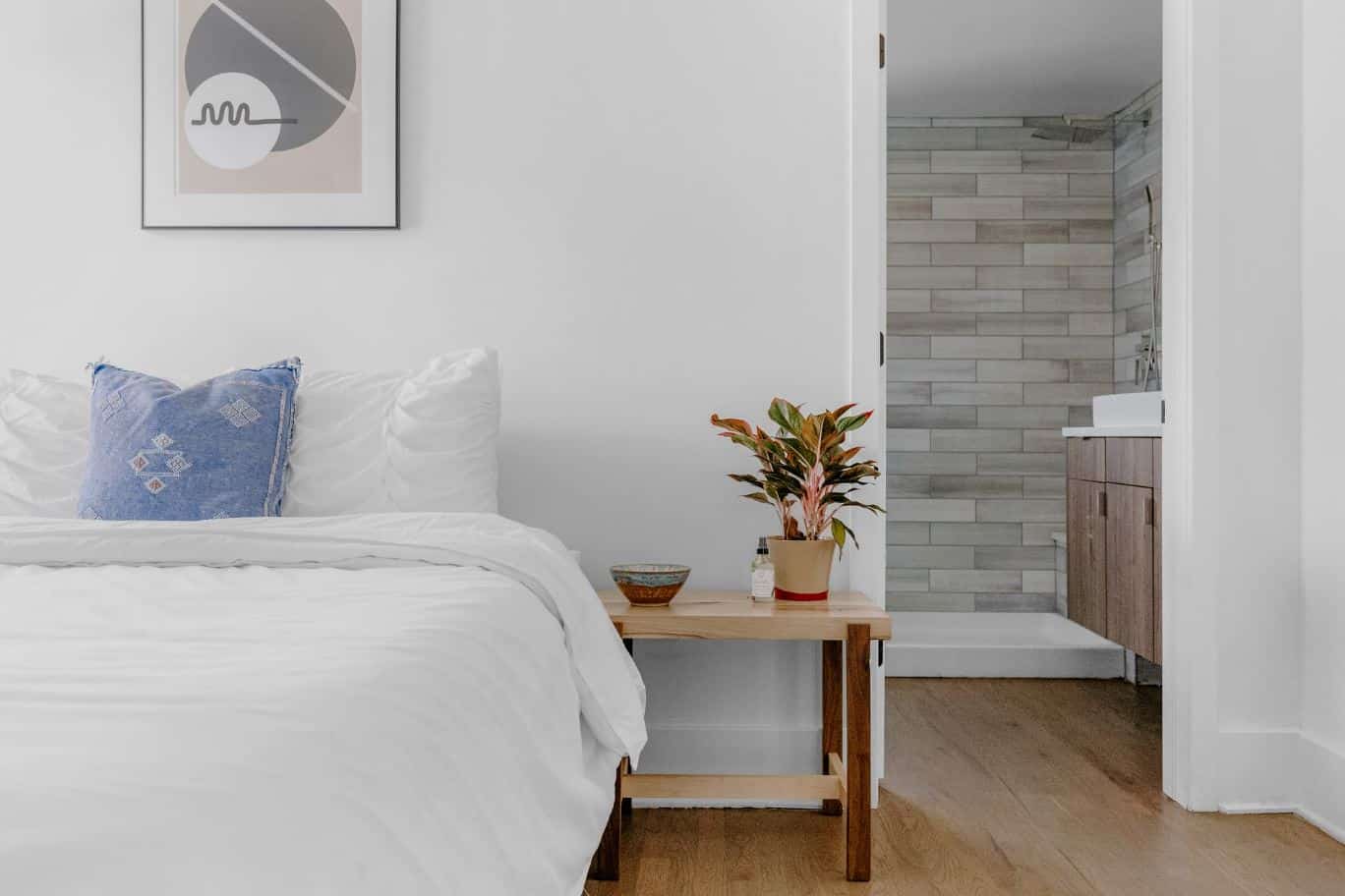 Queen size bed with white sheets and a blue pillow.