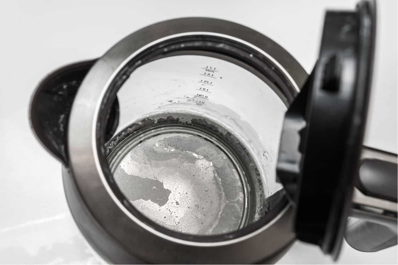 see through black and silver kettle with heavy limescale build up