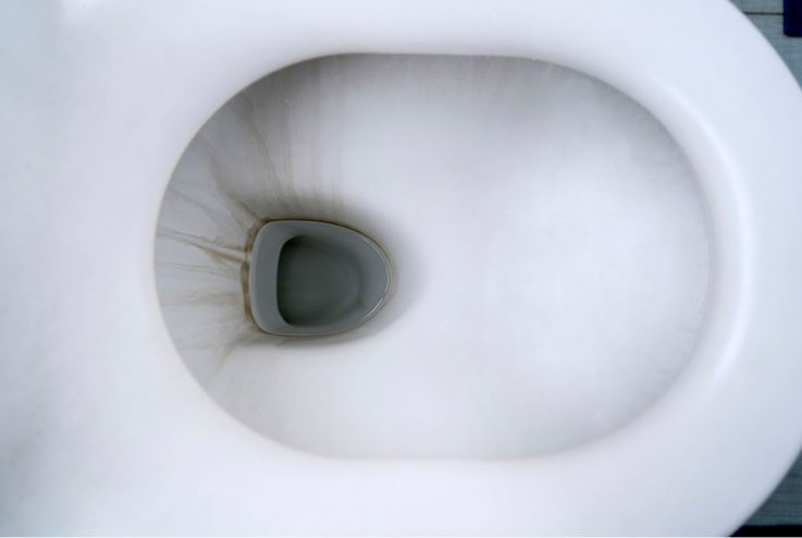 an inside look into a hard water stained white porcelain toilet bowl