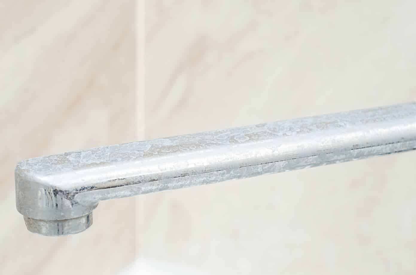 bathroom basin tap that is heavily stained with soap scum
