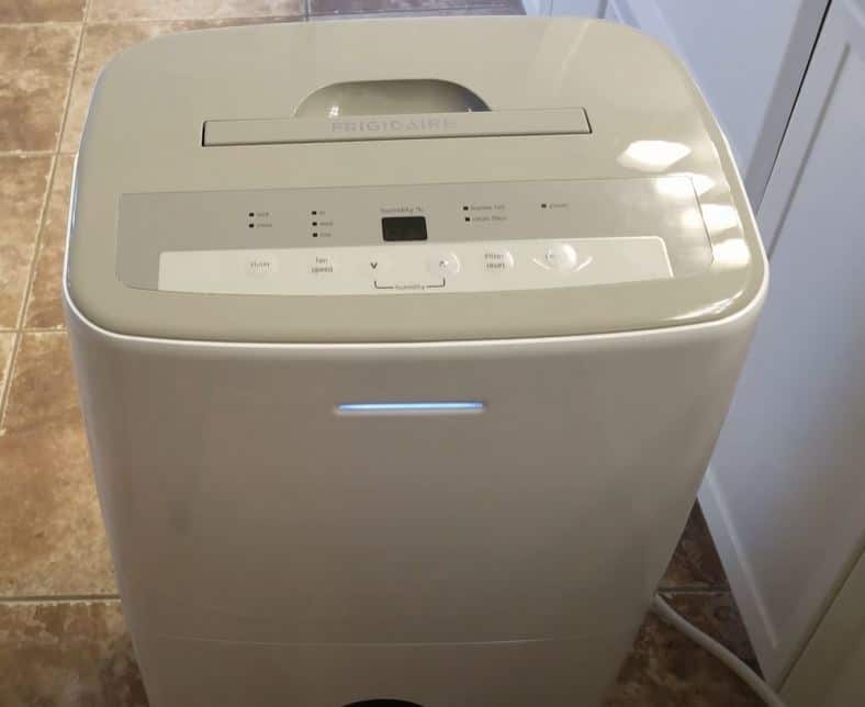 white frigidaire dehumidifier exterior being cleaned