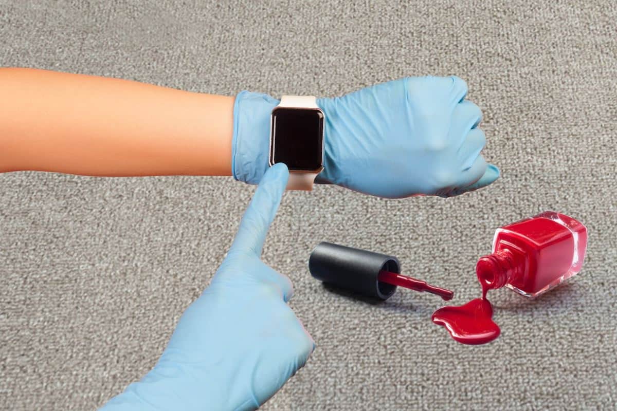 cleaner pointing to their watch after red nail polish has spilt on carpet